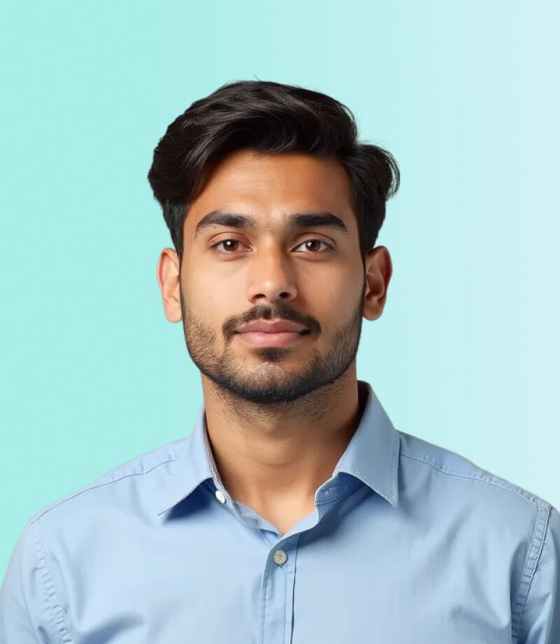 A man with short dark hair and a trimmed beard, wearing a light blue collared shirt, stands against a light blue gradient background, appearing ready to share tips as an online video maker.