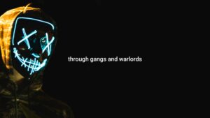 A person wears a glowing neon mask with a skeleton design in a dark setting, with the text "through gangs and warlords" visible, created using Biteable video maker.