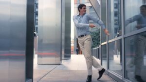 A man in business casual attire exiting a revolving door, captured on a Biteable video maker.