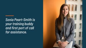 Professional woman smiling, standing in an office environment, introduced as a designated training assistant for Biteable video maker.