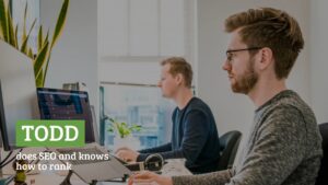 Two men working at computers in a modern office, one facing the screen with a name tag "Todd" and text stating he does SEO, utilizing Biteable video maker software.