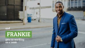 A confident man in a blue suit stands on a city street with the text "Biteable video maker gets us working as a team" overlaid.