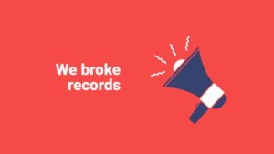 Red background with white text reading "We broke records" next to an illustrated blue megaphone emitting lines to indicate sound.